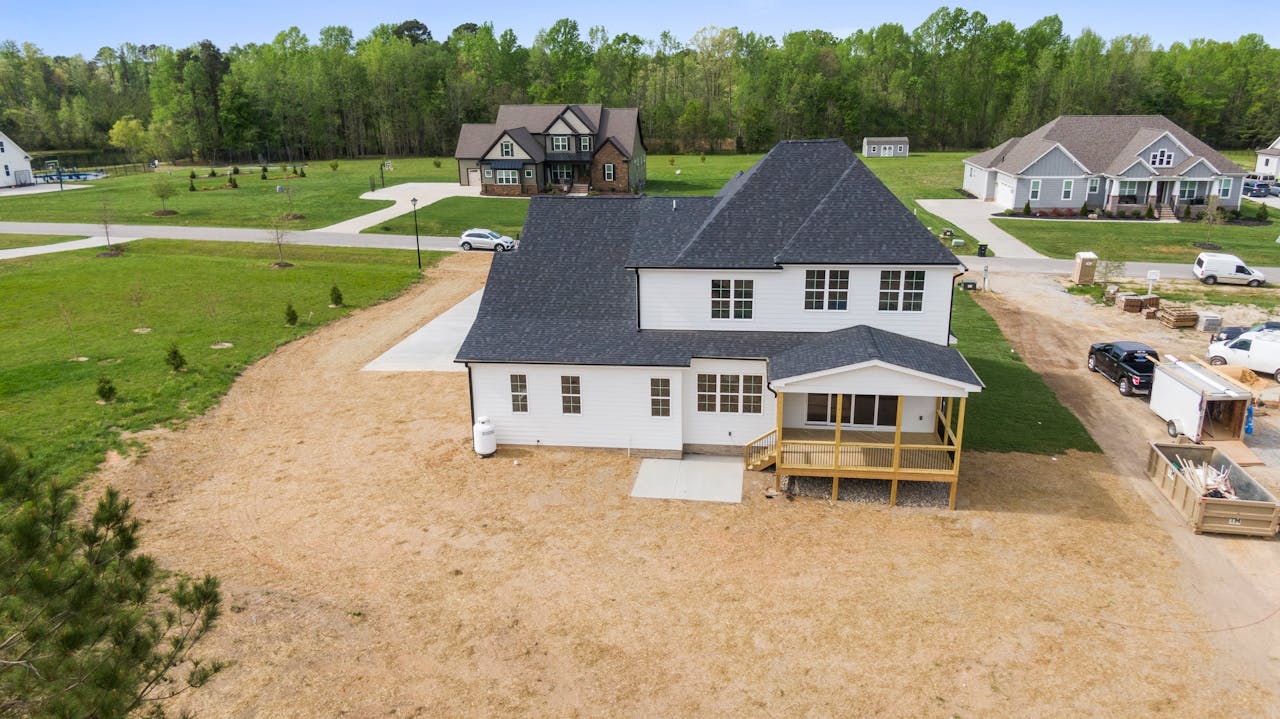 About Aerial shot of a suburban home under construction in Youngsville, NC with surrounding greenery.